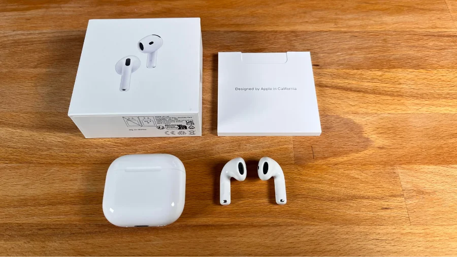 Lieferumfang und Verpackungsinhalt der AirPods 4 ANC auf einem Holztisch liegend.