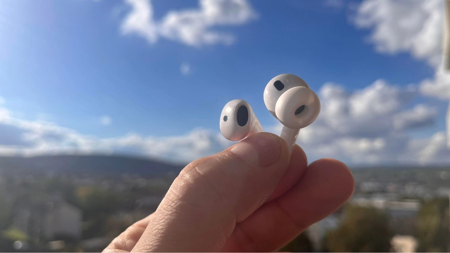 AirPods 4 ANC und AirPods Pro 2 zwischen meinen Fingern haltend.