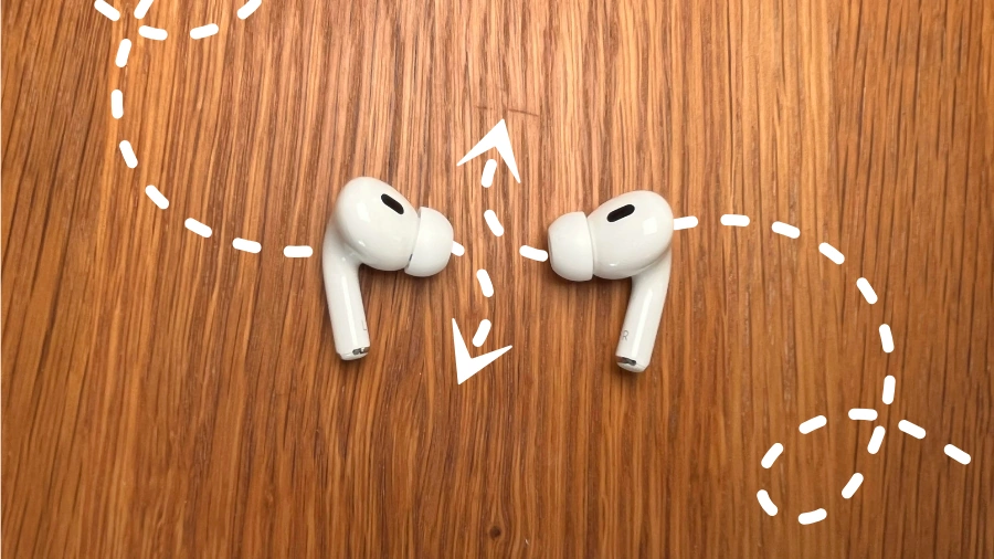 AirPods Pro 2 auf einem Holztisch mit Pfeilen die durch die AirPods gehen